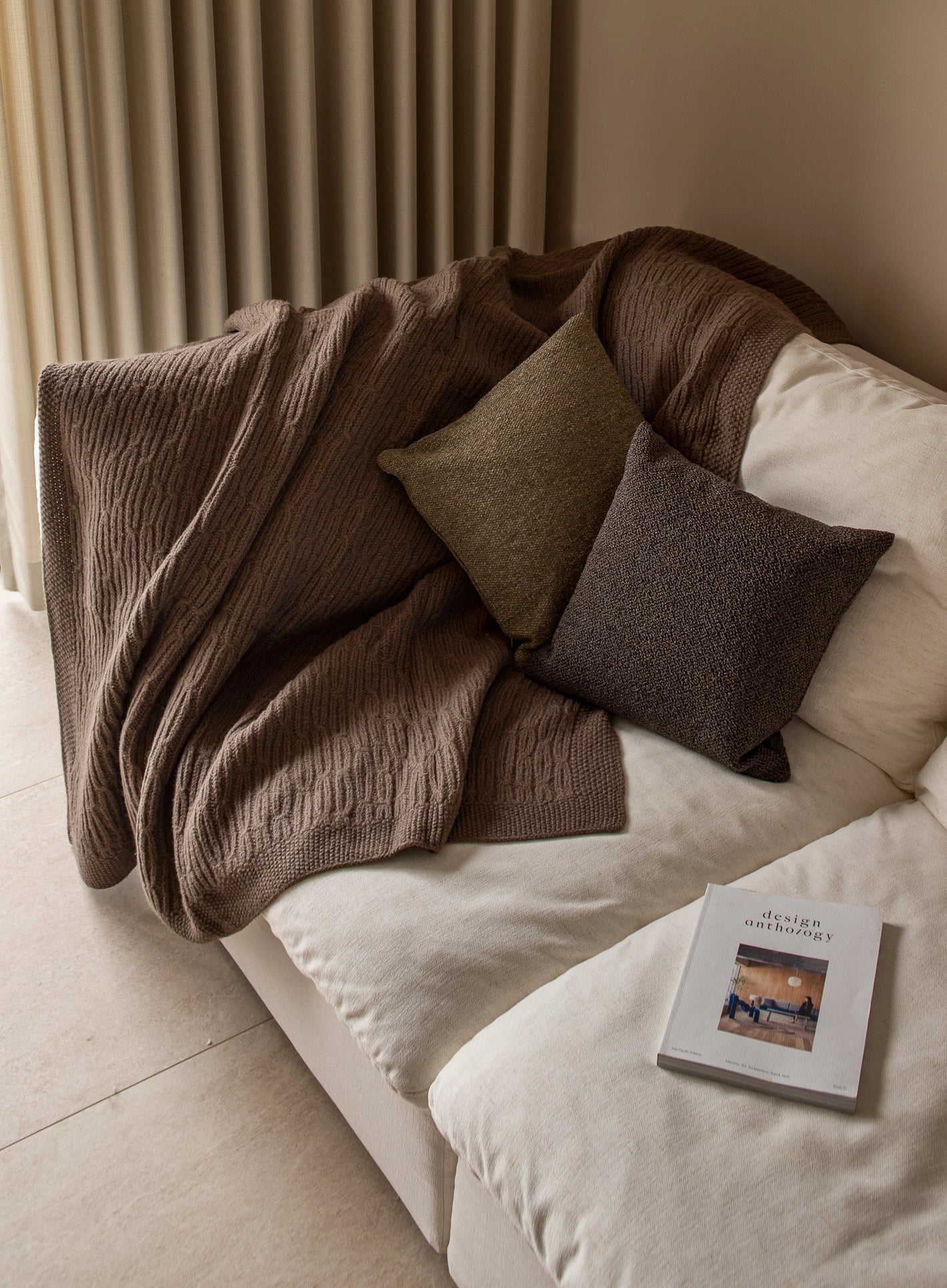 White sofa with dark throw and cushions