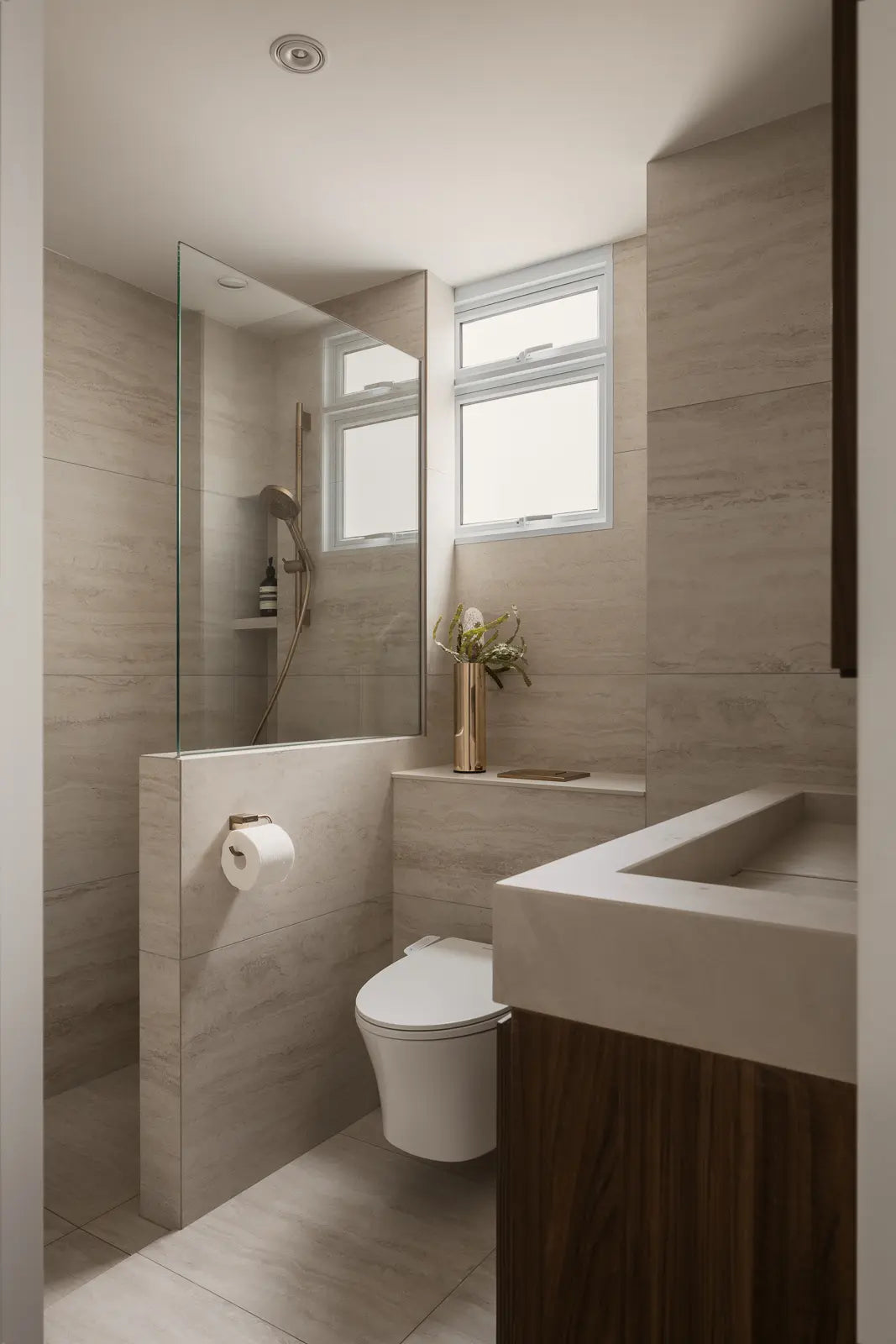 Minimalist bathroom with stone-inspired tiles, an integrated sink, and dark wood vanity cabinetry.