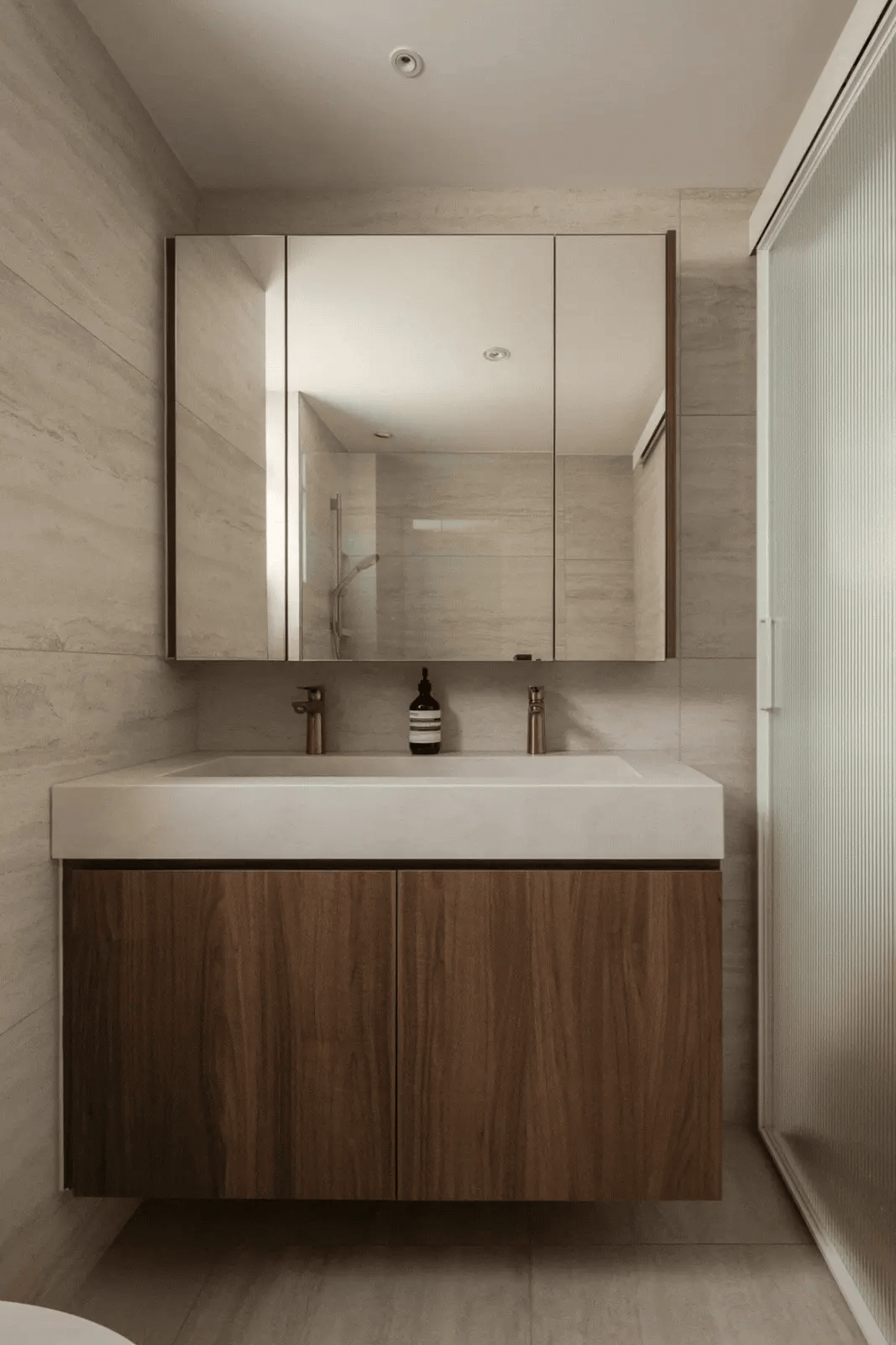 Minimalist bathroom featuring an integrated sink, dark wood cabinetry, and a built-in mirror cabinet.