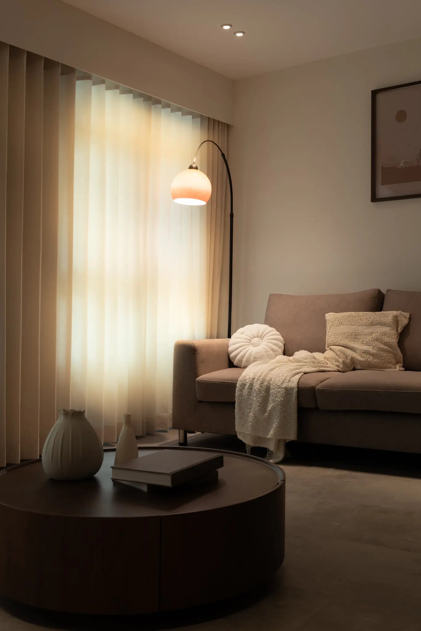Modern living room with warm lighting, a standing lamp, round coffee table and sofa